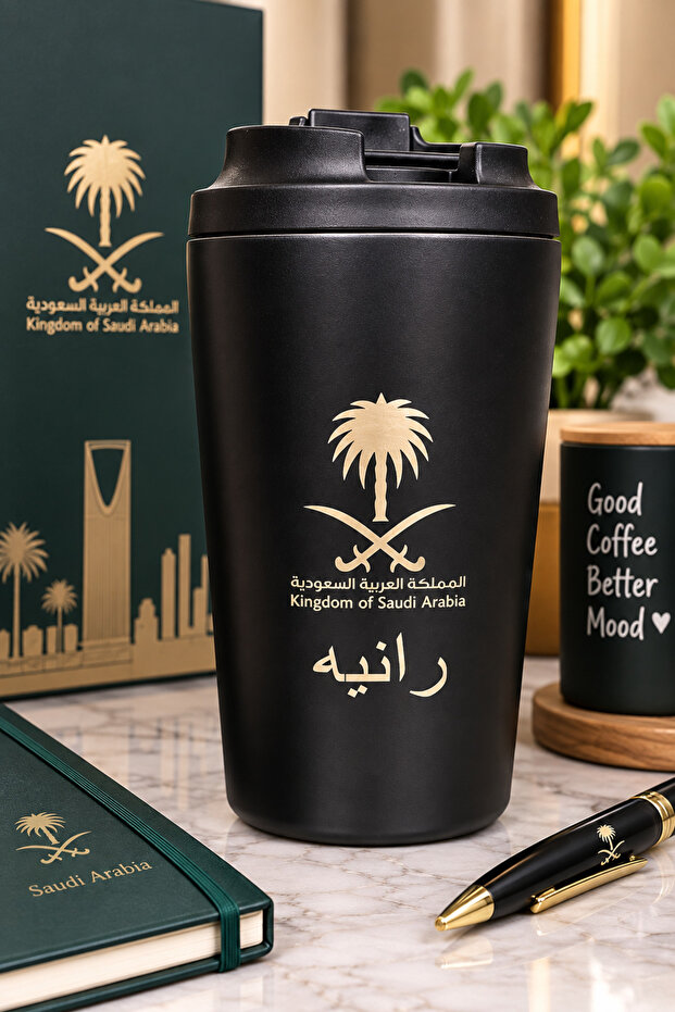 كوب حراري أنيق باللون الأسود مع غطاء عملي محكم، مزين بشعار المملكة العربية السعودية وتصميم مميز باللون الذهبي، مناسب للمشروبات الساخنة والباردة والاستخدام اليومي.