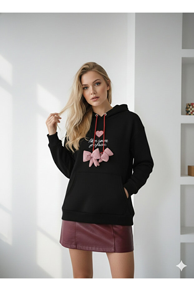 Women's three-thread soft touch long sleeve sweatshirt with pocket detail, drawstring tie, and embroidered bow accent.