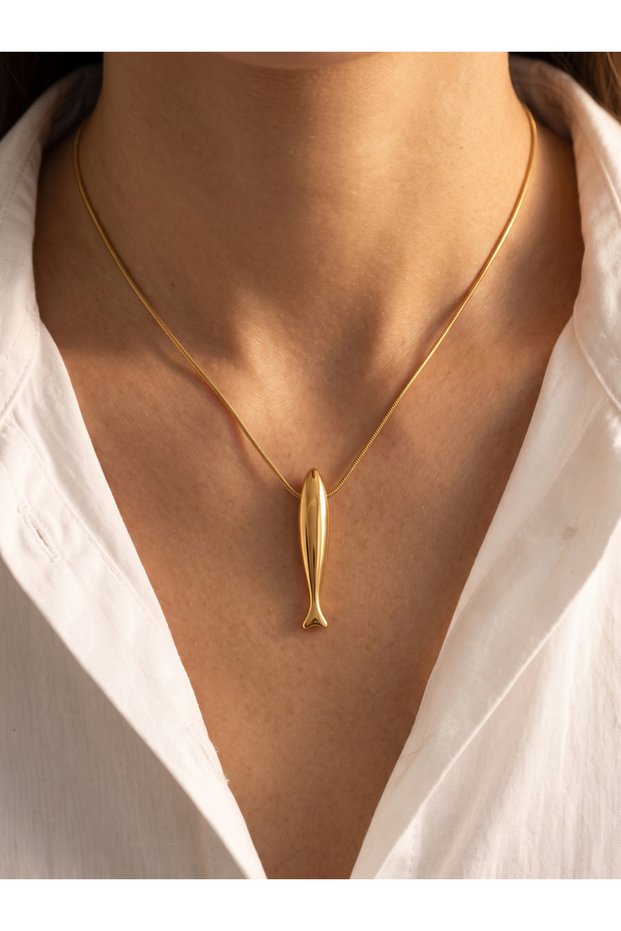 A necklace with a long, golden fish pendant