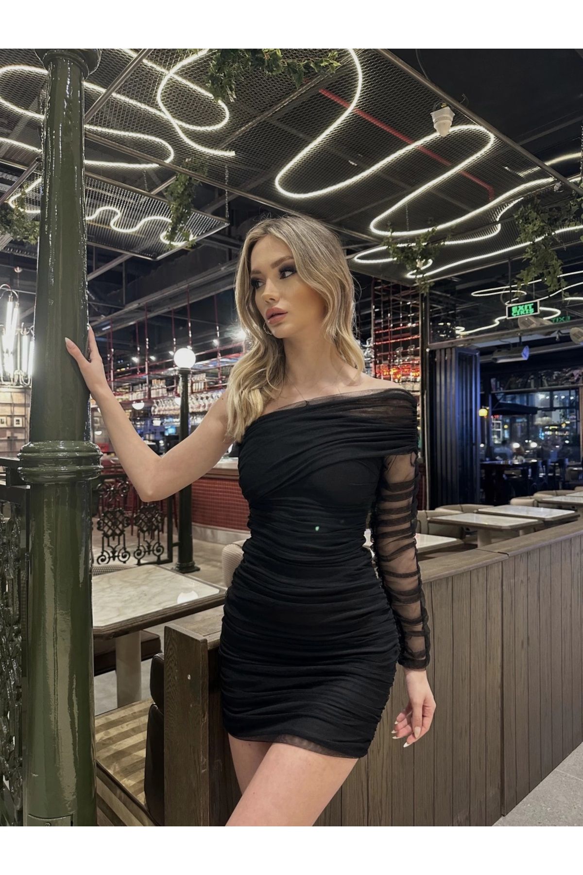 elle porte une mini jupe avec un bras drama à lastérisque