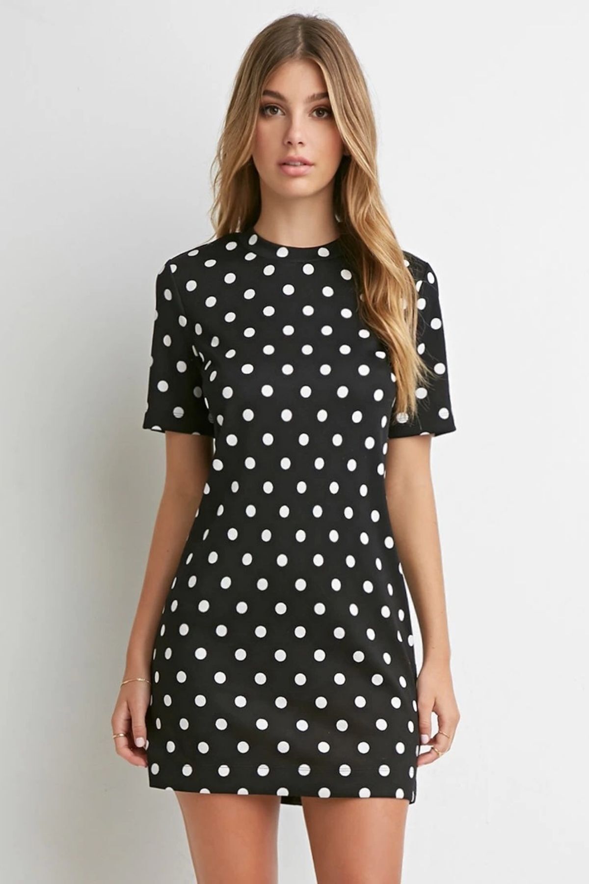 elle porte une robe de mini boy à pois noirs