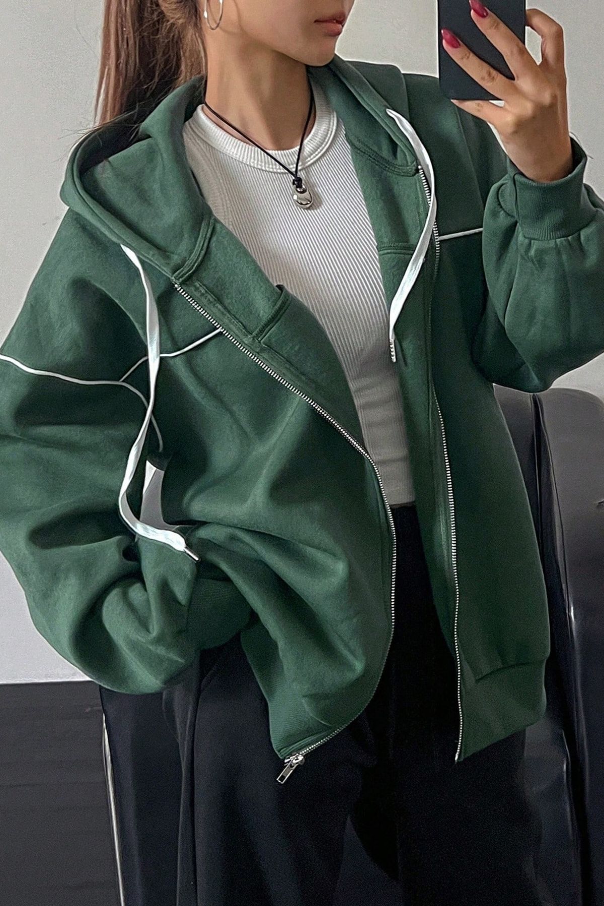 la femme est un pull à capuche verte