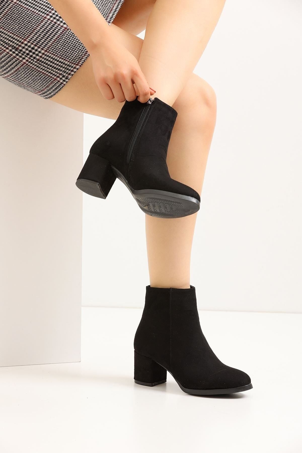 une femme en daim noir avec des talons plats court