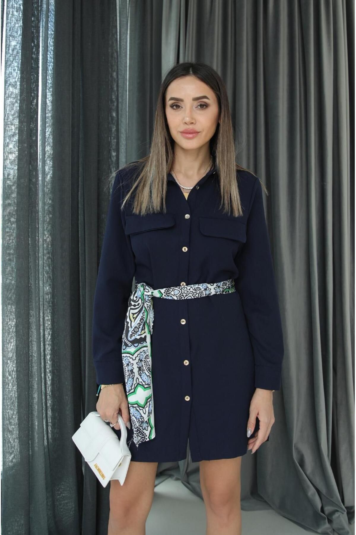 cest une robe bleu marine avec un bouton devant