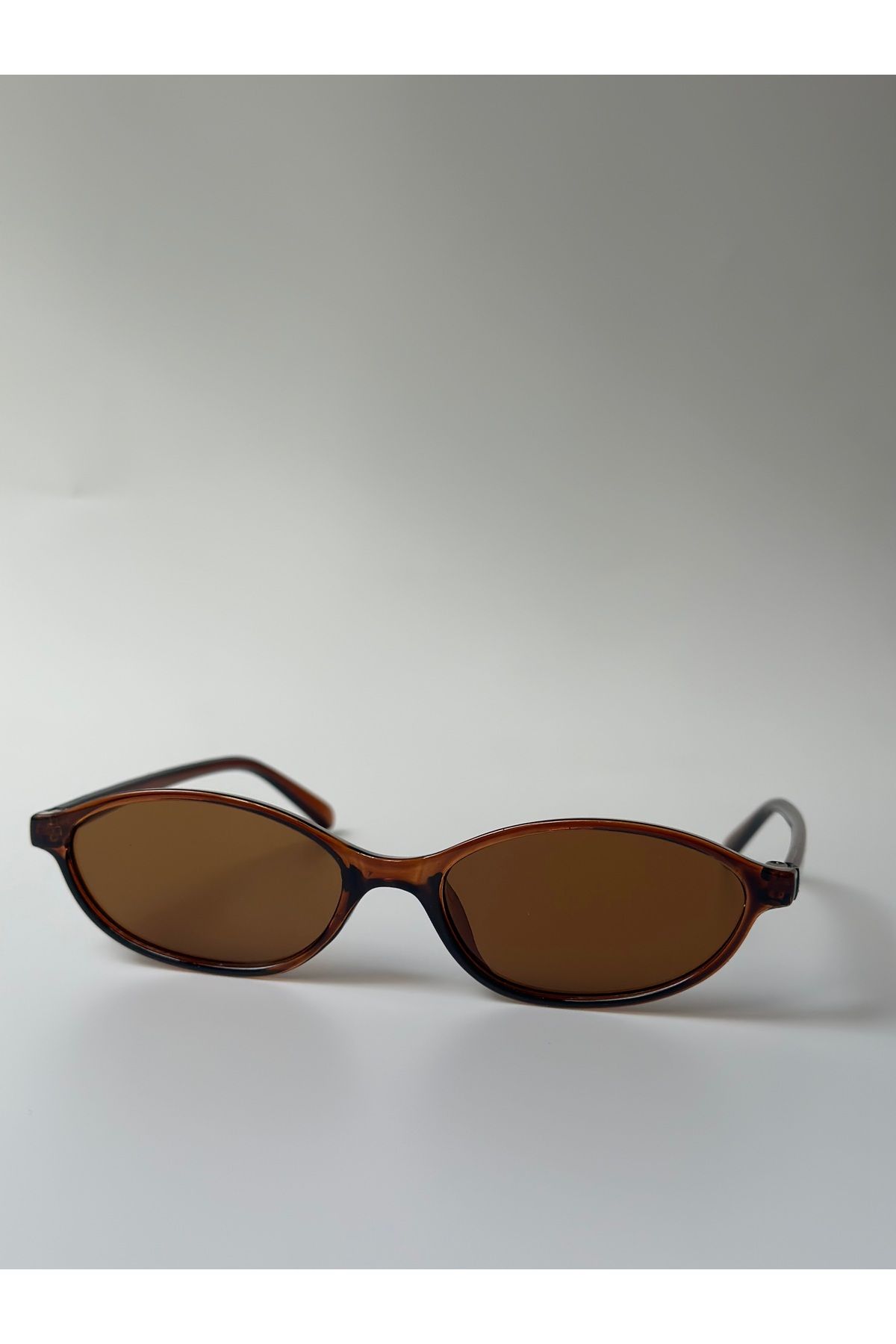 Aksu Atelier Minimal Oval Kahverengi Güneş Gözlüğü – Unisex, Şeffaf Kahve Çerçeve