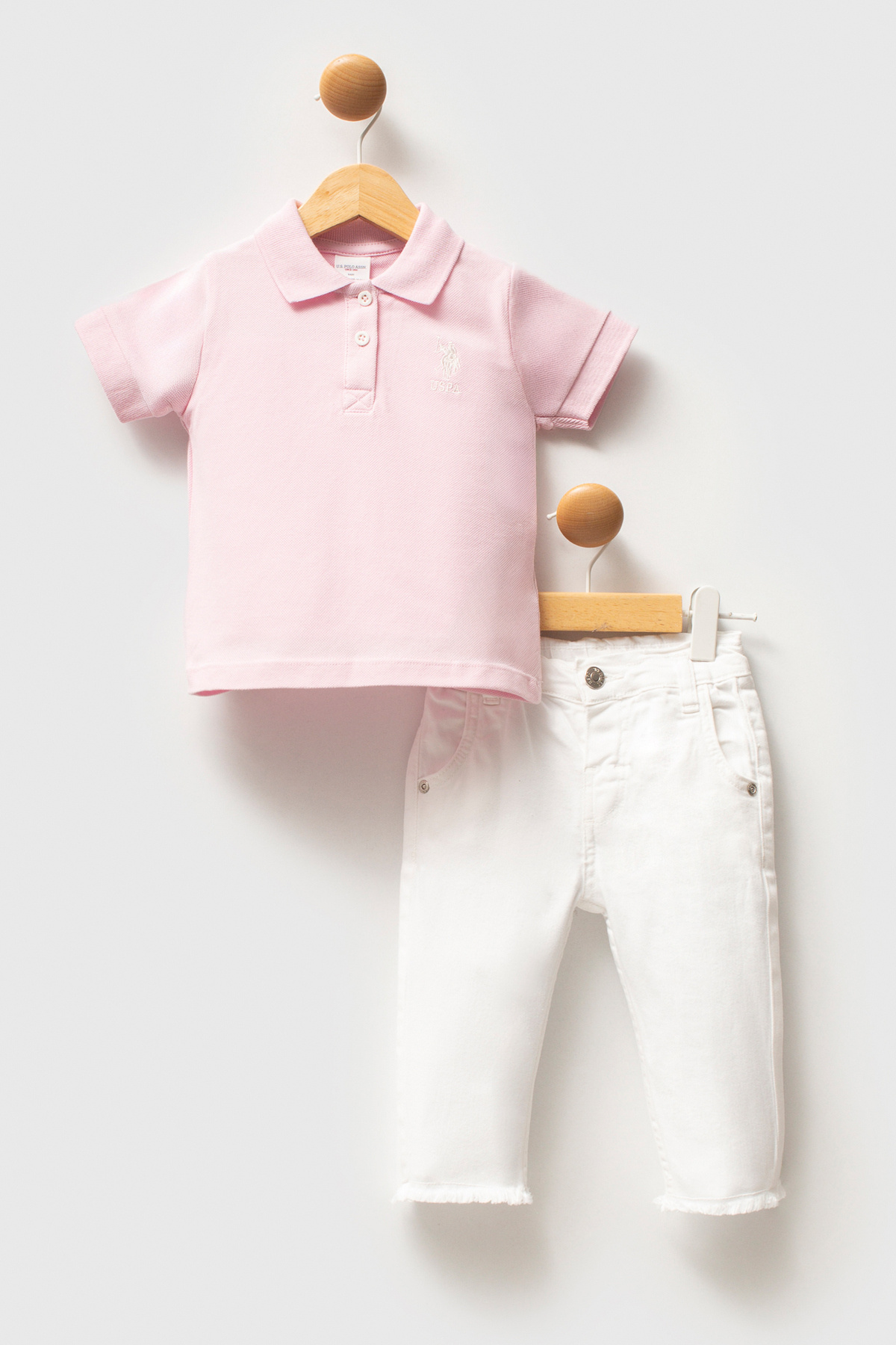 تی‌شرت و شلوار جین دخترانه طرح پولو ۱۰۰٪ پنبه صورتی گرد و خاکی، ست ۲ عددی یو اس پولو کد :(50322905-VR050) U.S. Polo Assn.