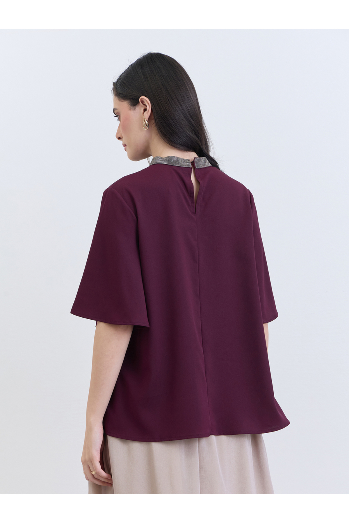 بلوزة نسائية أرجوانية اللون مزينة بالخرز عند الرقب...