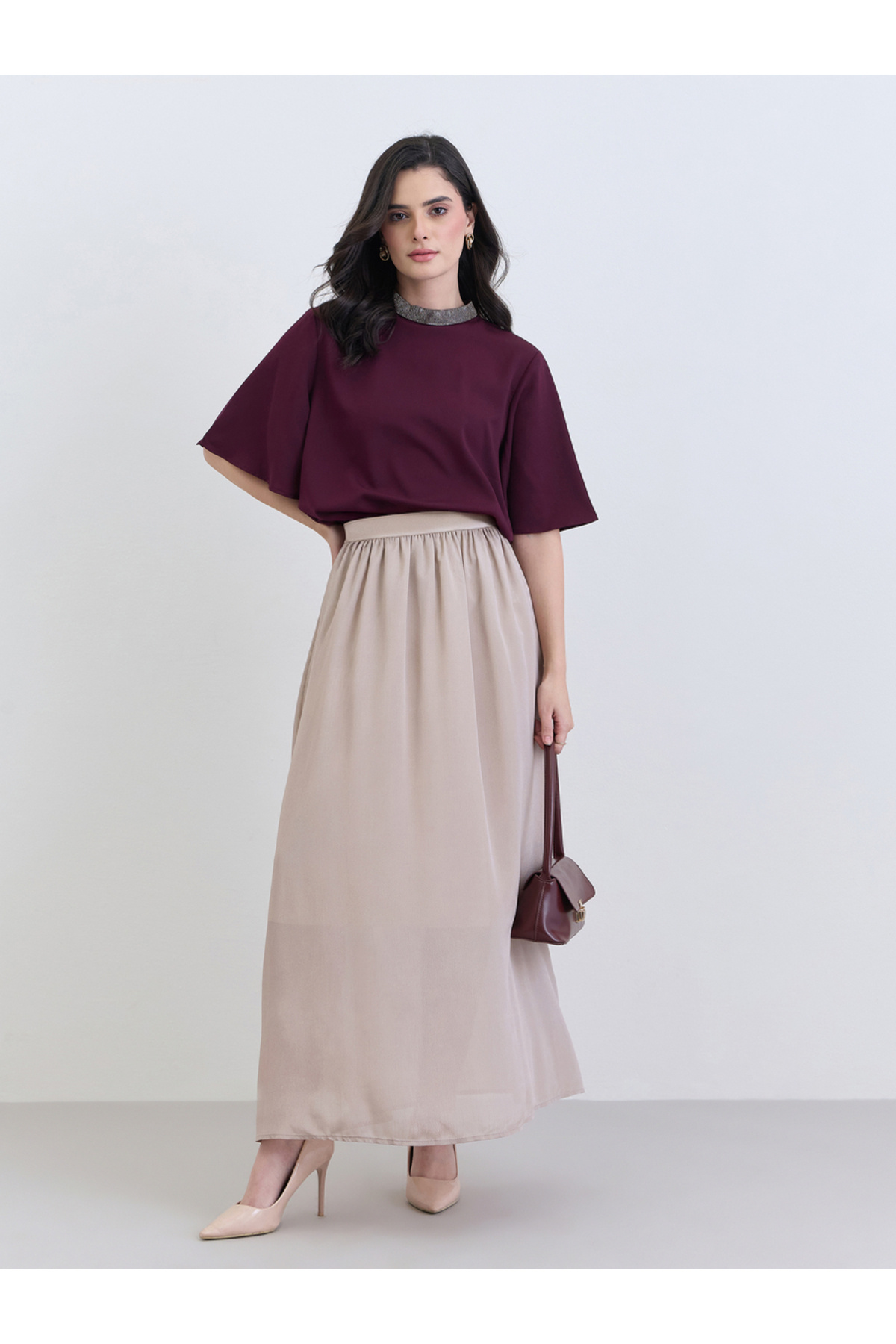 بلوزة نسائية أرجوانية اللون مزينة بالخرز عند الرقب...