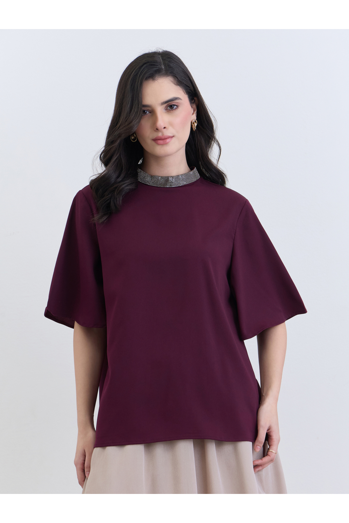 بلوزة نسائية أرجوانية اللون مزينة بالخرز عند الرقب...