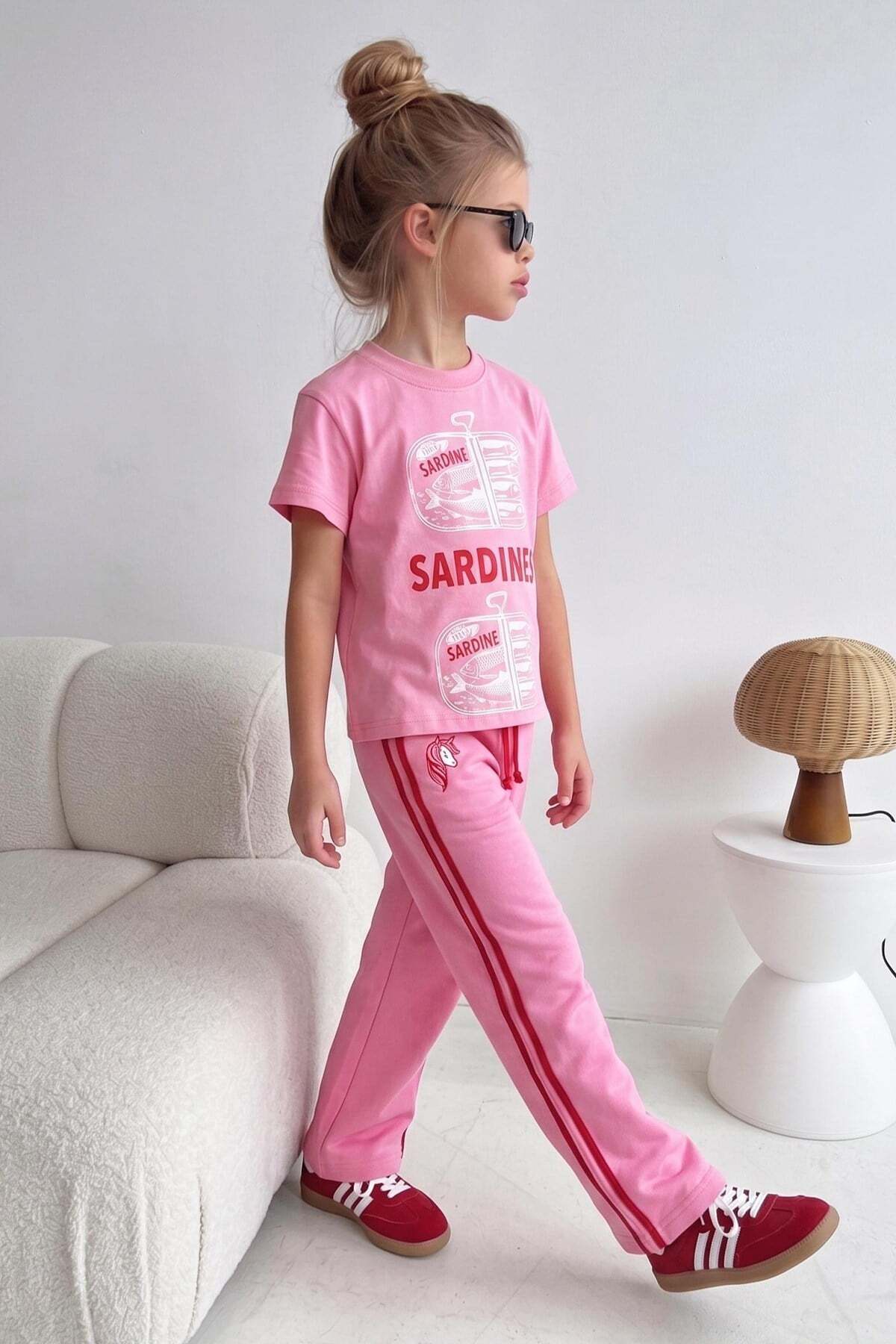 A cotton T-shirt and sports pants set in pink color with drawings of girls printed on it.