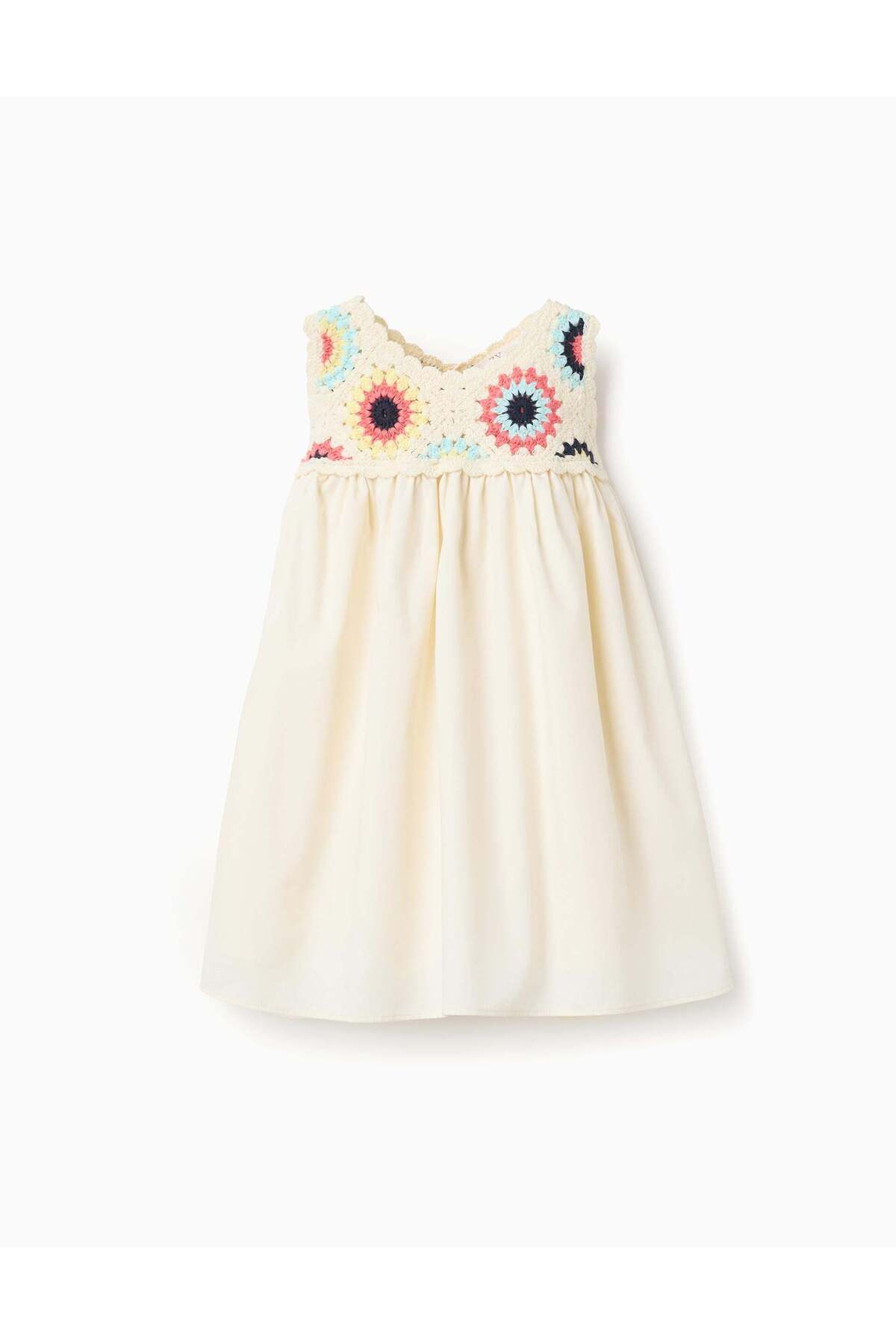 A dress made of double fabric with crochet flowers for young girls in light beige color
