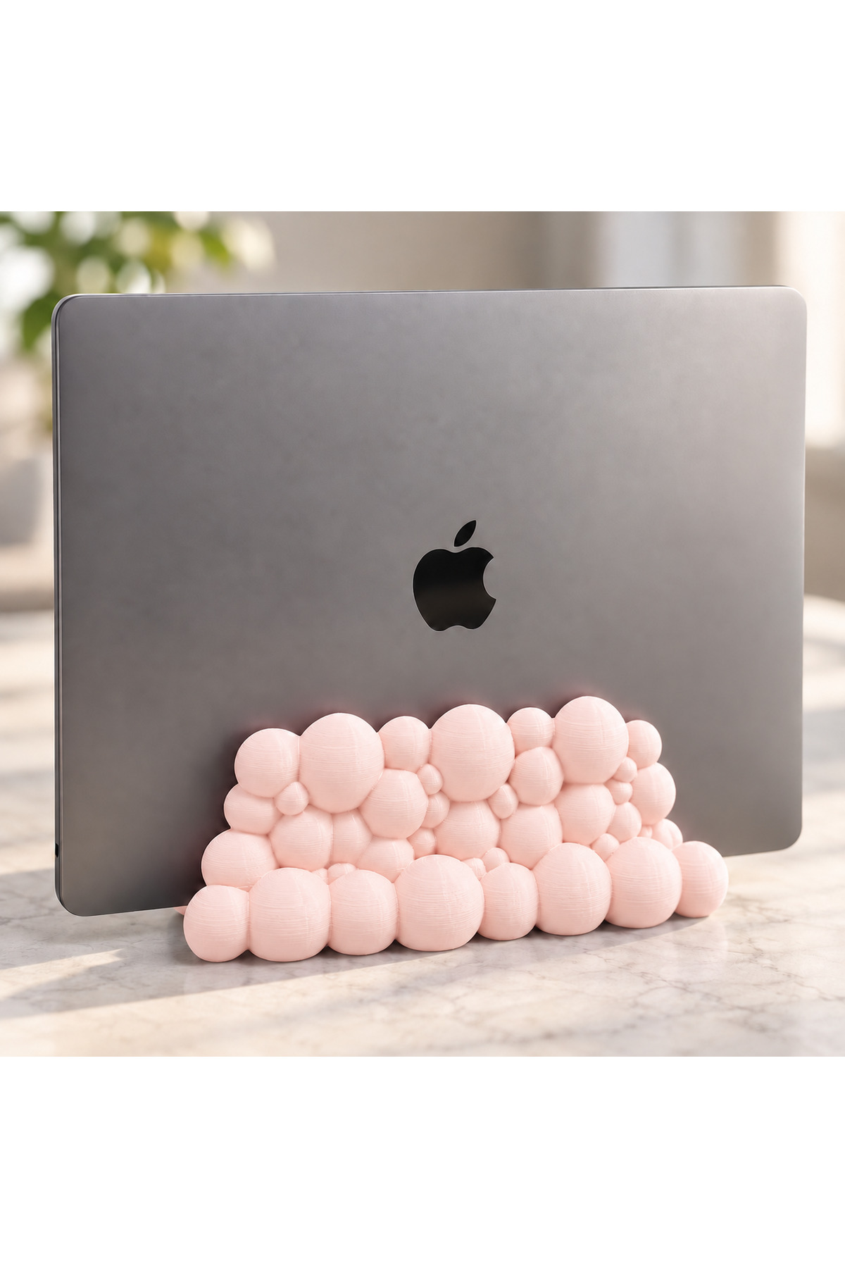 Nina Bubble dikey notebook tutucu stand, pastel pembe renkli kabarcık tabanla dizüstü bilgisayar yuvasına yerleştirilmiş masaüstü kullanım görünümü.
